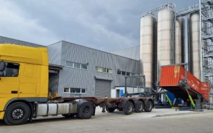 Container tipper for unloading on trailer