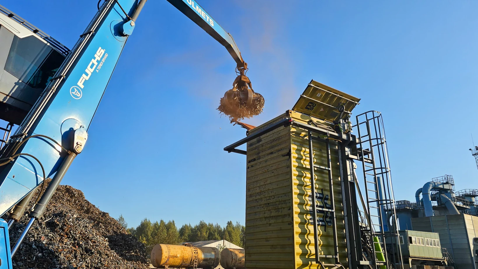 Metal scarp is being loaded into container with help of Container Tilter